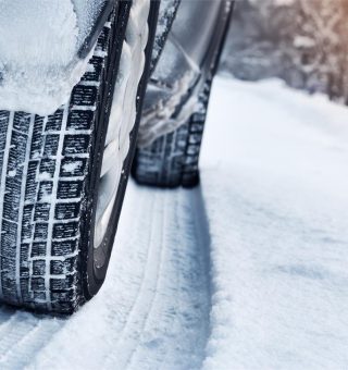 Closeup of car tires in winter on the road covered with snow